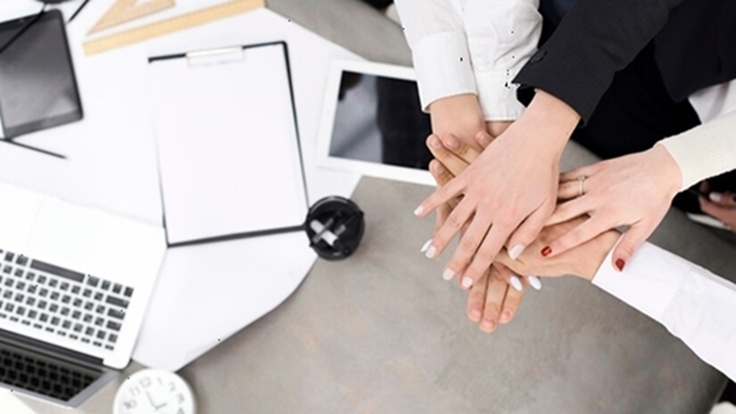 Des mains réunies autour d’une table, symbole du travail en équipe